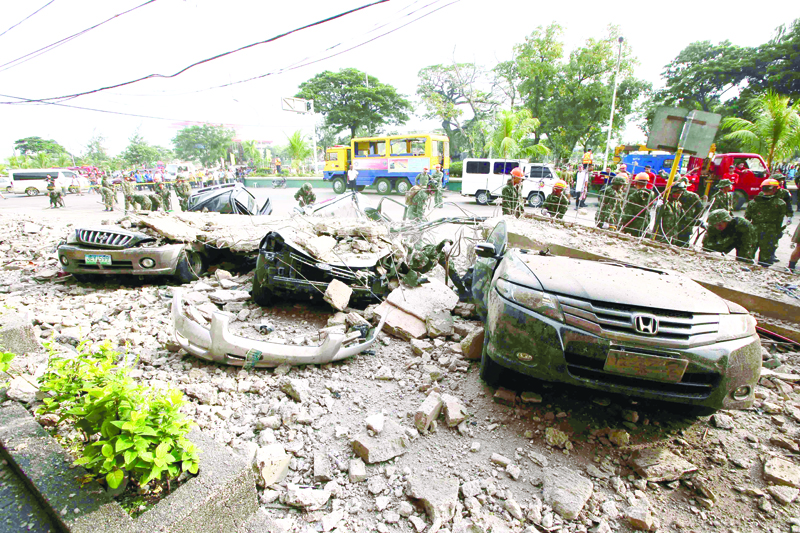 PARKED. One of several damaged cars lie under a rubble outside a building in downtown Cebu following the 7.2-magnitude earthquake last Oct. 15. Fortunately, no one was inside any of the cars during the tremor. (AP FOTO)